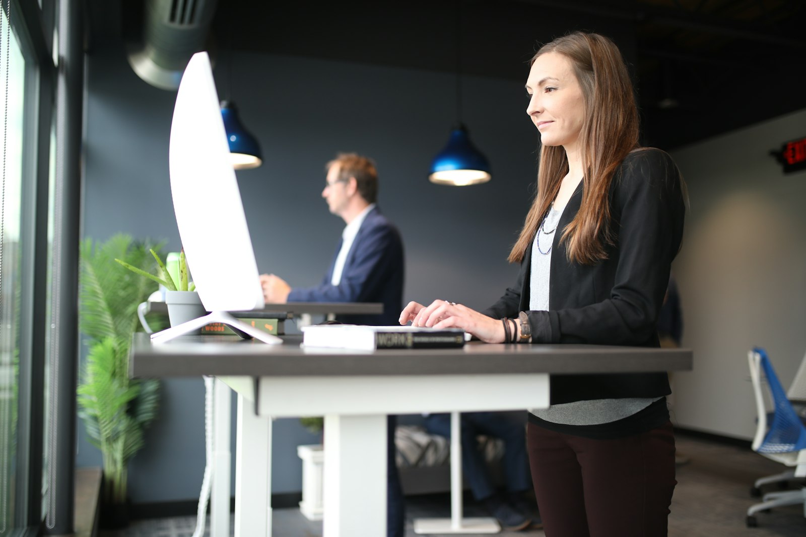 Title clerk working through a deal on her computer at a standing desk
