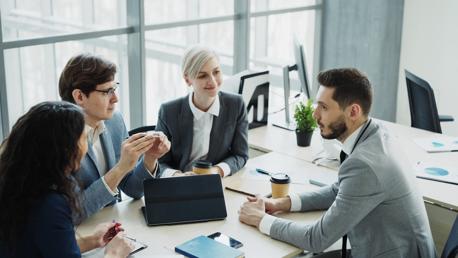 A dealership team reviewing deal documents together at an office desk